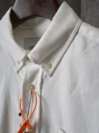 White button-up shirt collar with gold buttons and orange detail tag