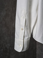 White buttoned shirt sleeve with stitched pocket panel and gold buttons