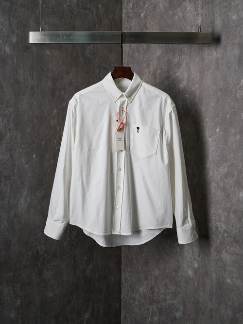 White button-up shirt with pointed collar, chest pocket, and gold buttons