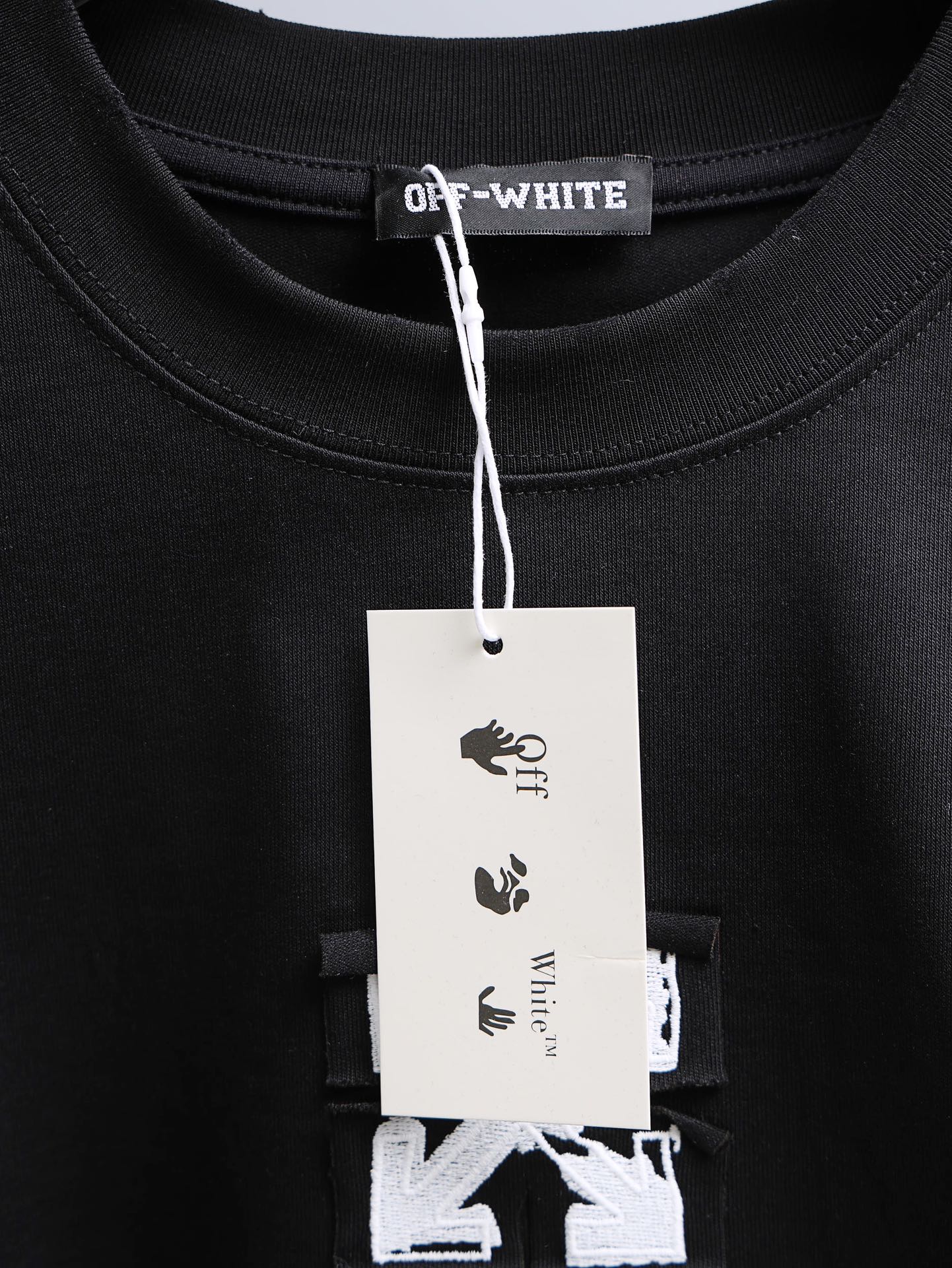 Off-White black T-shirt collar with brand tag hanging from neckline