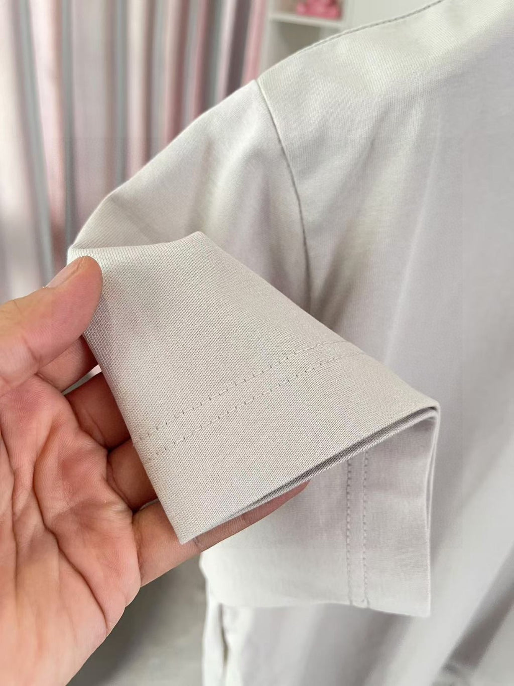 Short-sleeve T-shirt hem detail, light gray cotton with double stitching