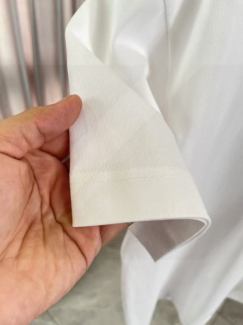 White short-sleeve T-shirt hem and side seam, held in hand
