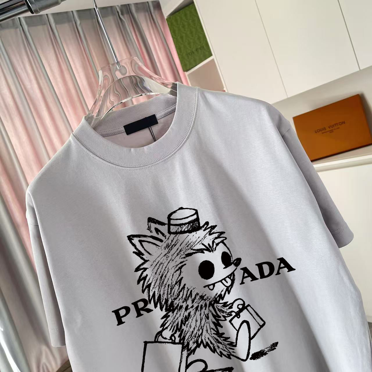 Short-sleeve T-shirt, light gray, crew neck, close-up of front cartoon logo