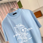 Light blue T-shirt close-up showing crew neck and white graphic character print