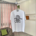 White T-shirt with cartoon graphic and PRADA-style logo print on the front