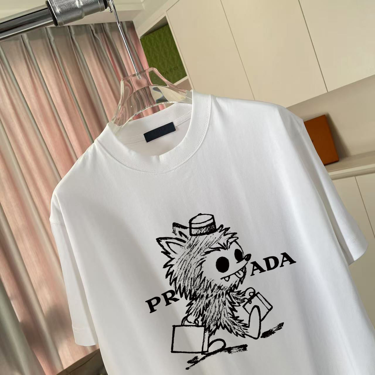 White T-shirt close view with cartoon graphic and PRADA-style logo print