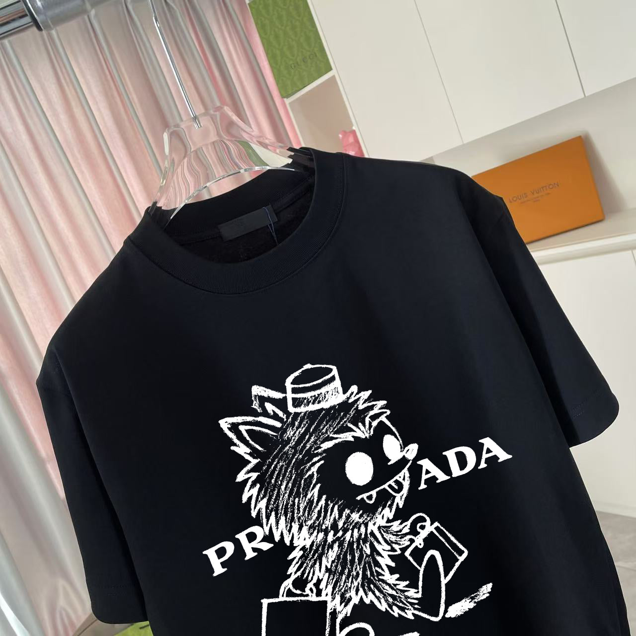 Black graphic T-shirt with large Prada logo and animal illustration