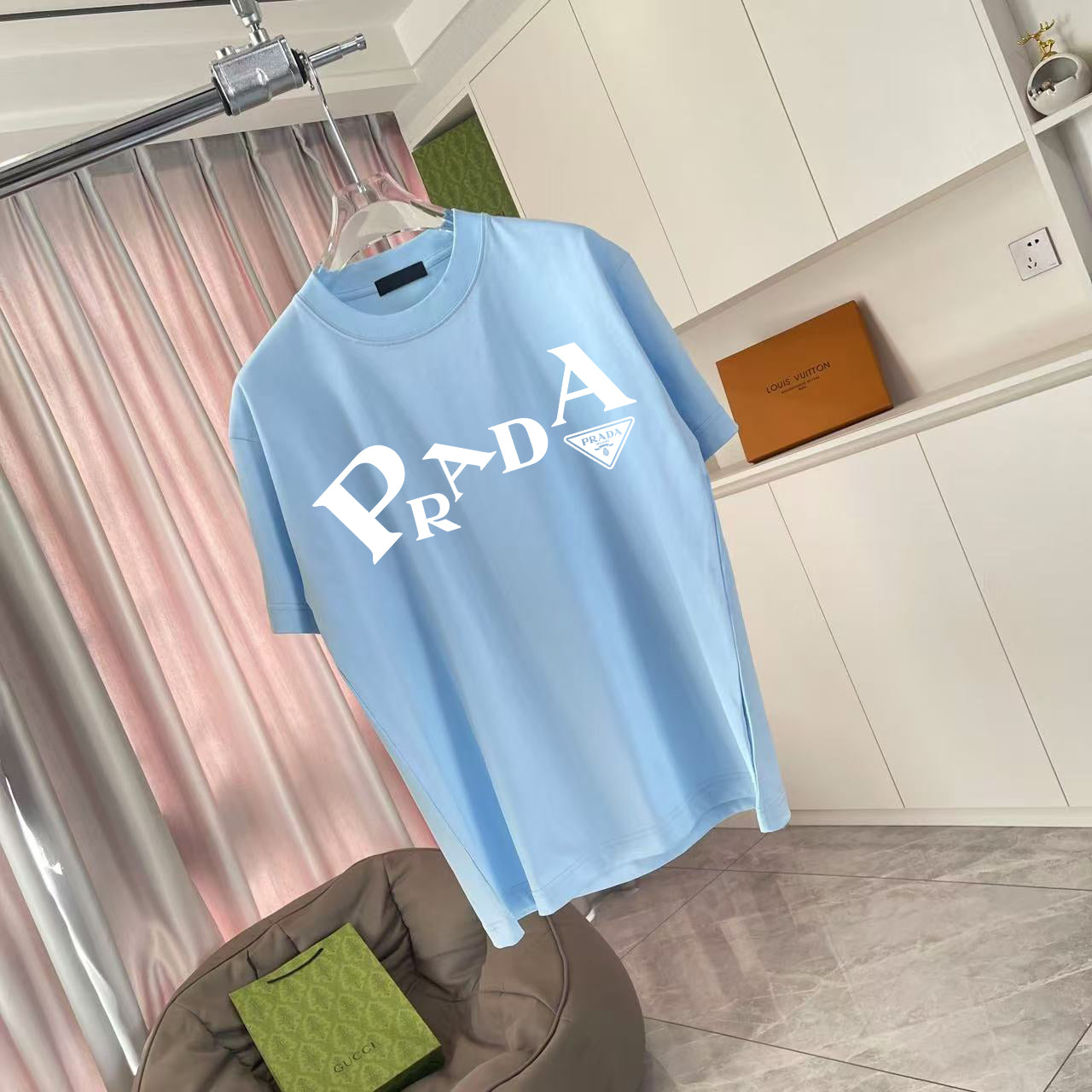 Light blue short-sleeve T-shirt on hanger, front logo print