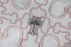 Close-up of embroidered cross patch with metallic centerpiece on T-shirt