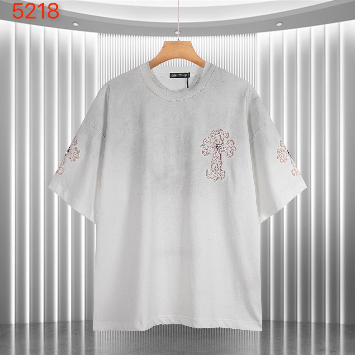 White short-sleeve T-shirt with small front cross graphic and embroidered sleeves