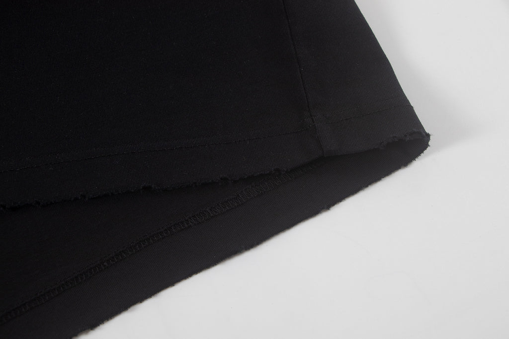 Black short-sleeve shirt hem with visible stitching and finish