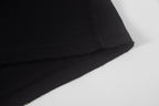 Black short-sleeve shirt hem with visible stitching and finish