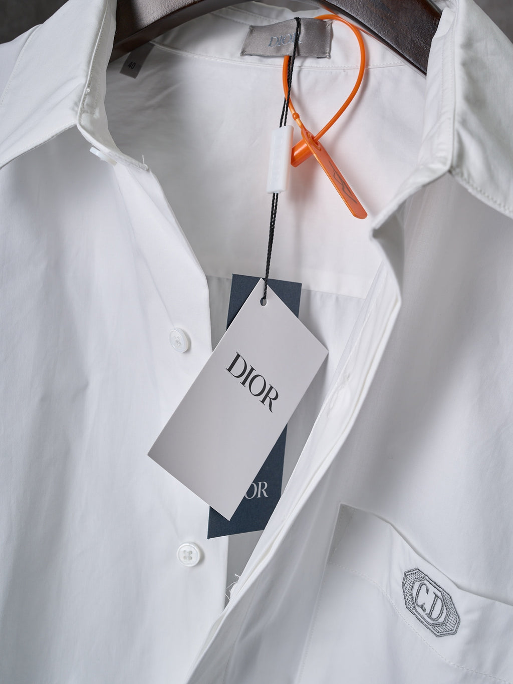 Dior white button-up shirt with orange tag string and front logo patch on chest
