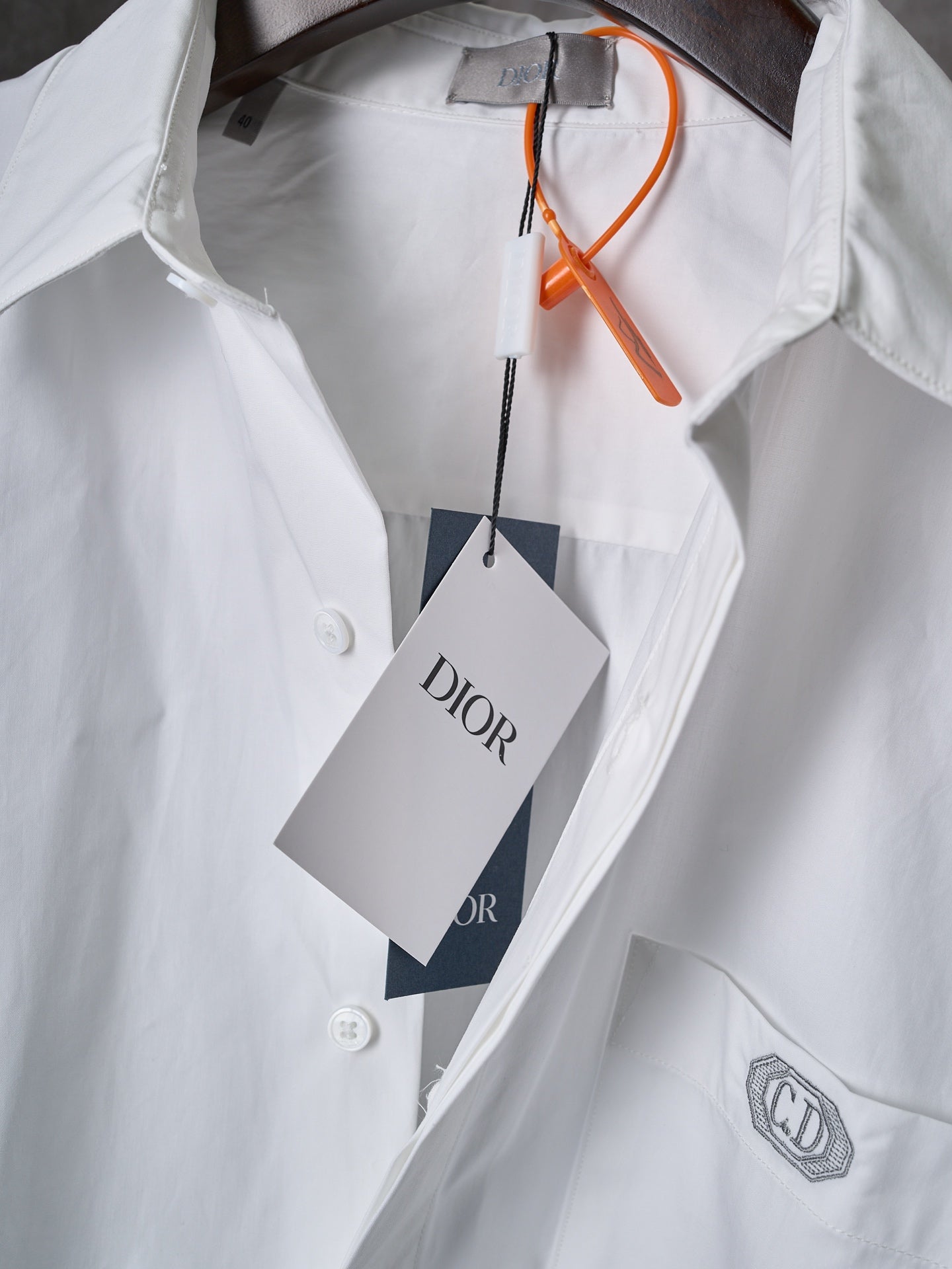 Dior white button-up shirt with orange tag string and front logo patch on chest