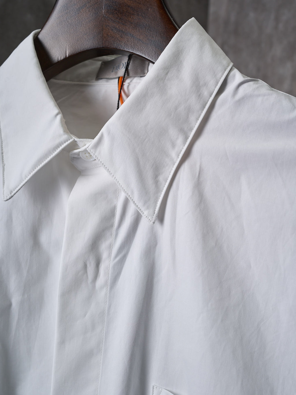 Dior white long-sleeve shirt collar close-up with stitched placket and neckline