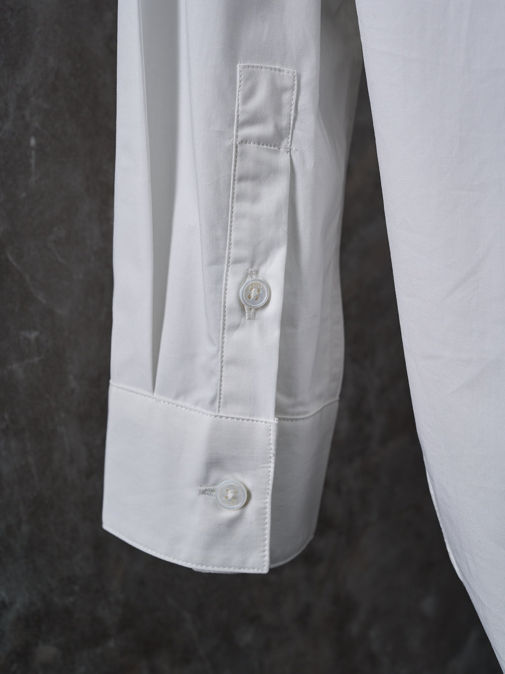 Dior white shirt sleeve cuff with buttoned placket and visible topstitching