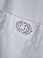 Dior embroidered logo patch on white fabric with fine dotted border stitching