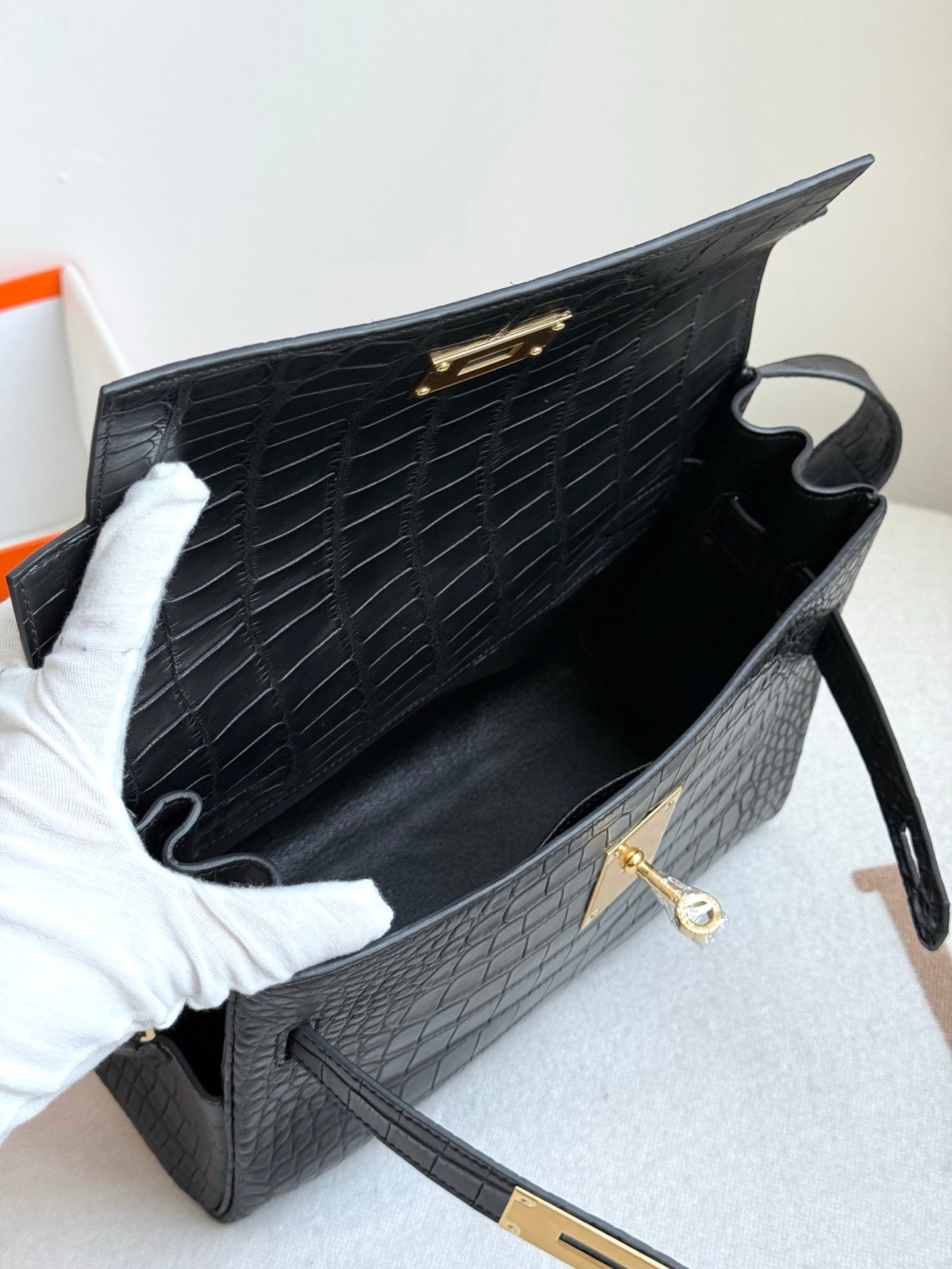 Hermes croc-textured shoulder bag open, dark blue interior and gold turn-lock on flap