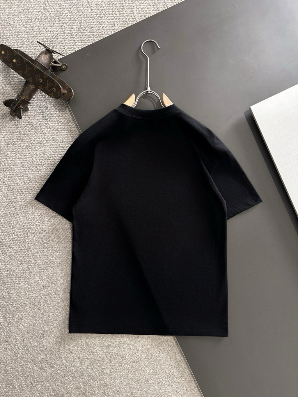 Black short-sleeve T-shirt hanging on a hanger