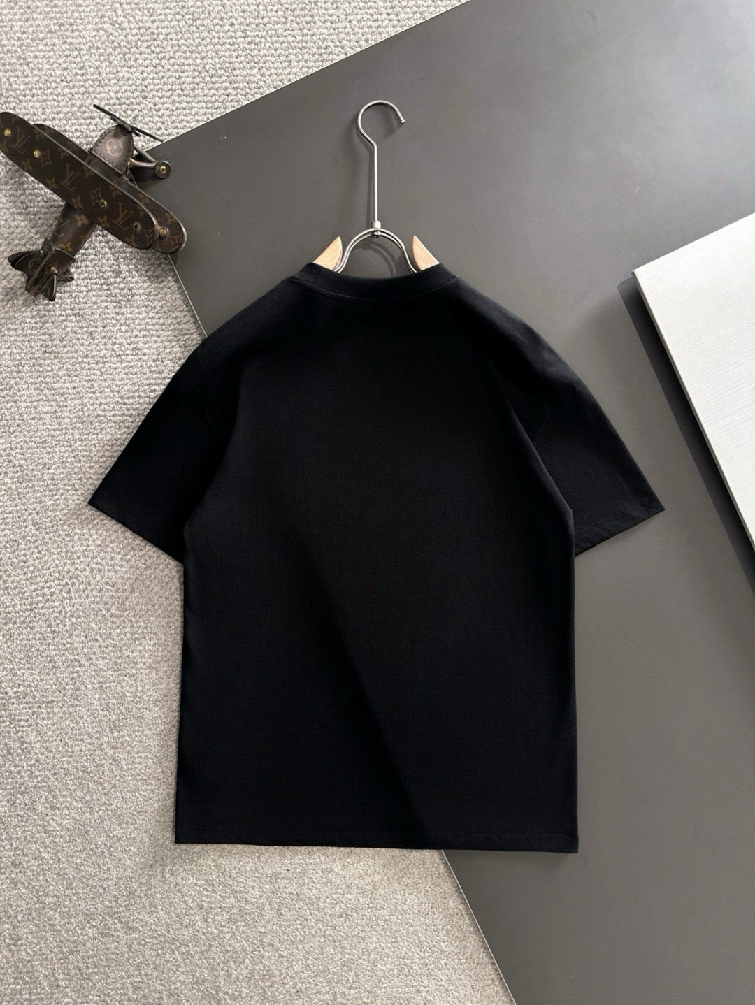 Black short-sleeve T-shirt hanging on a hanger