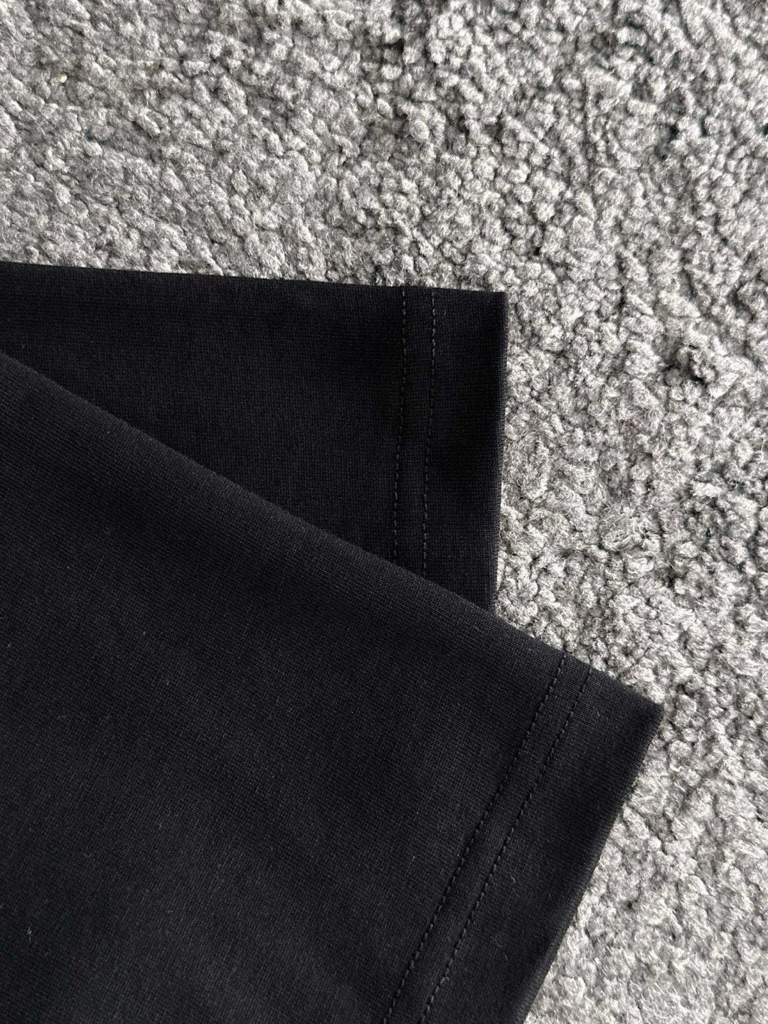Black T-shirt hem and side seam detail