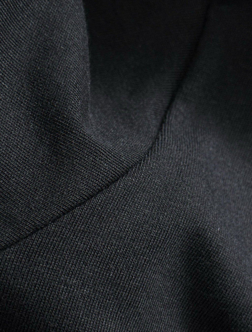 Black knit T-shirt texture near shoulder seam