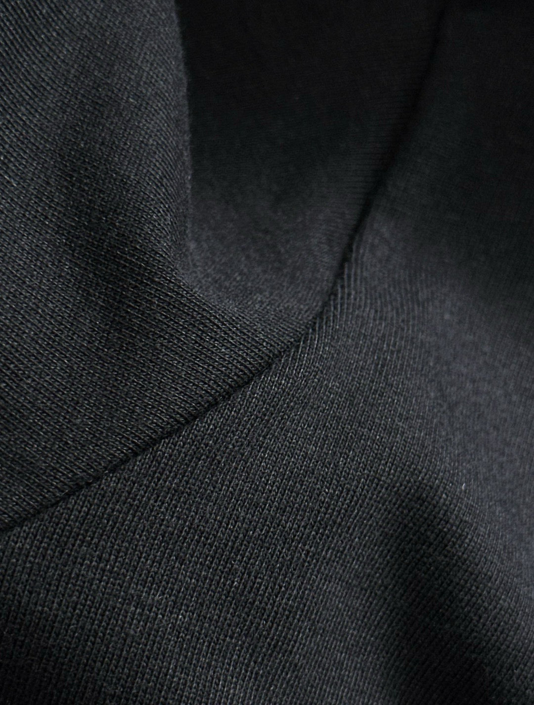 Black knit T-shirt texture near shoulder seam