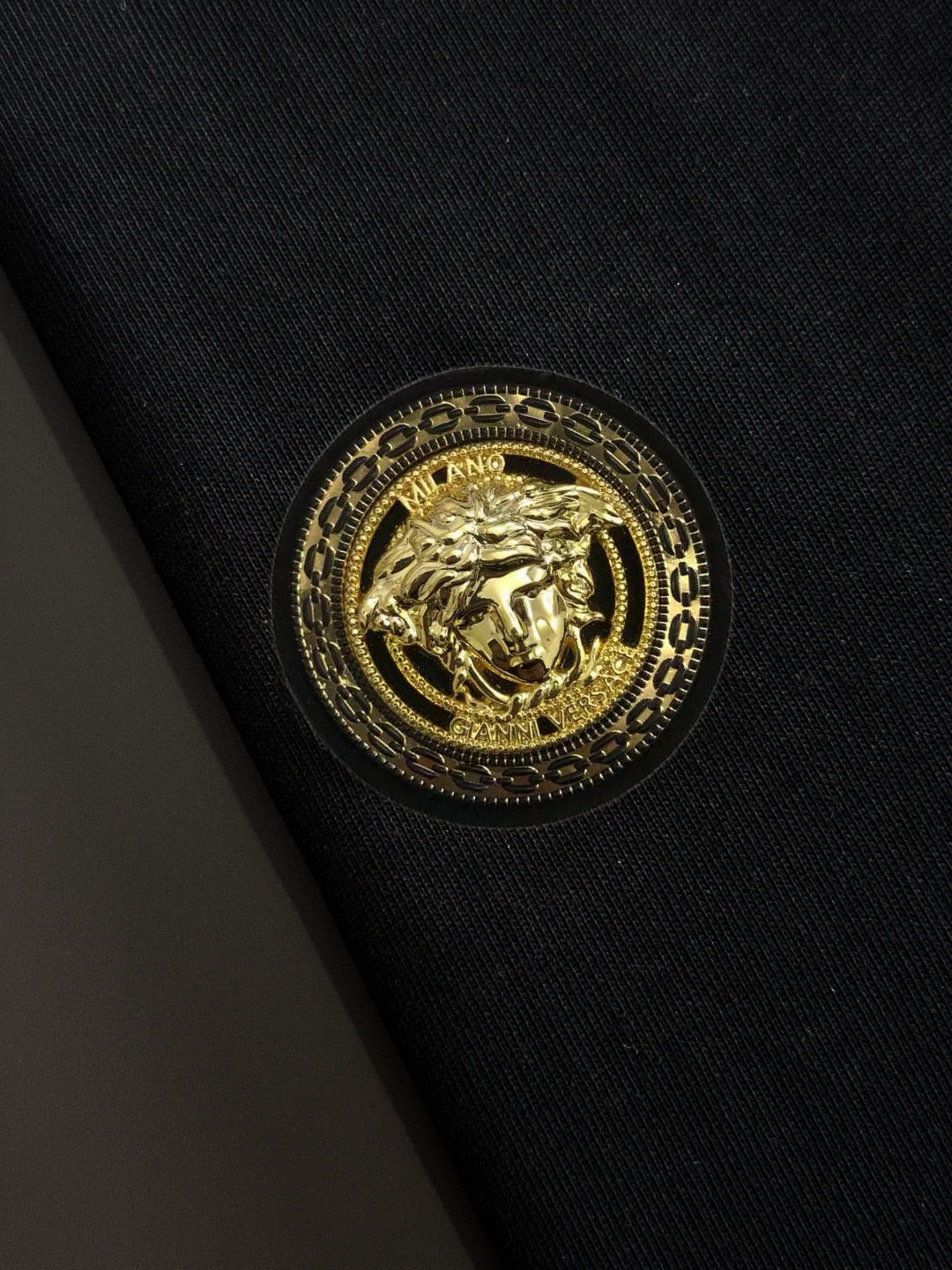 Gold crest emblem on black fabric