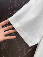 White T-shirt sleeve and hem, held by hand