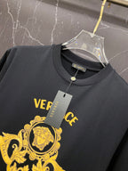 Black T-shirt with crew neck tag and partial gold Versace crest graphic on chest