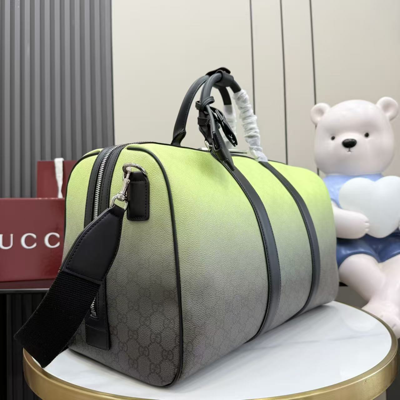 Green and gray monogram duffel bag with black shoulder strap and top zip