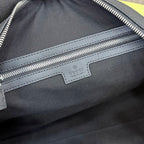 Monogram duffel bag close-up: Gucci label, silver zip track, black leather trim