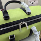 Green duffel bag close-up of top handle and silver zipper pull with black trim