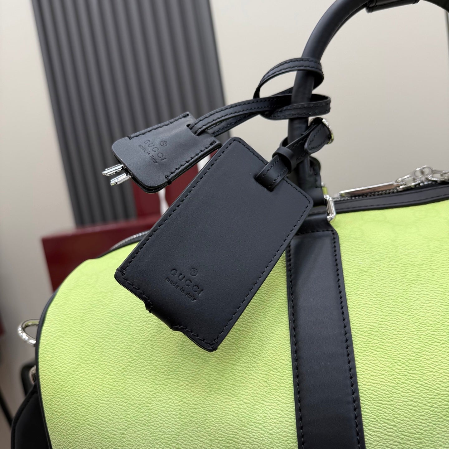 Gucci bag with navy leather strap, zip hardware and hanging label on lime green body