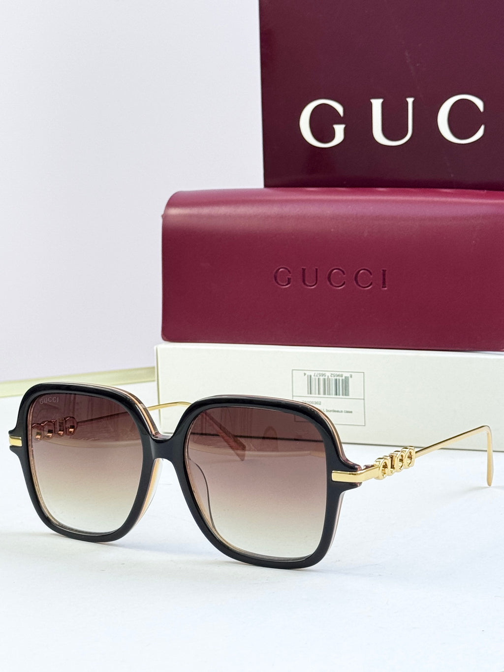 Black square sunglasses with brown-tinted lenses and gold-tone temple detail