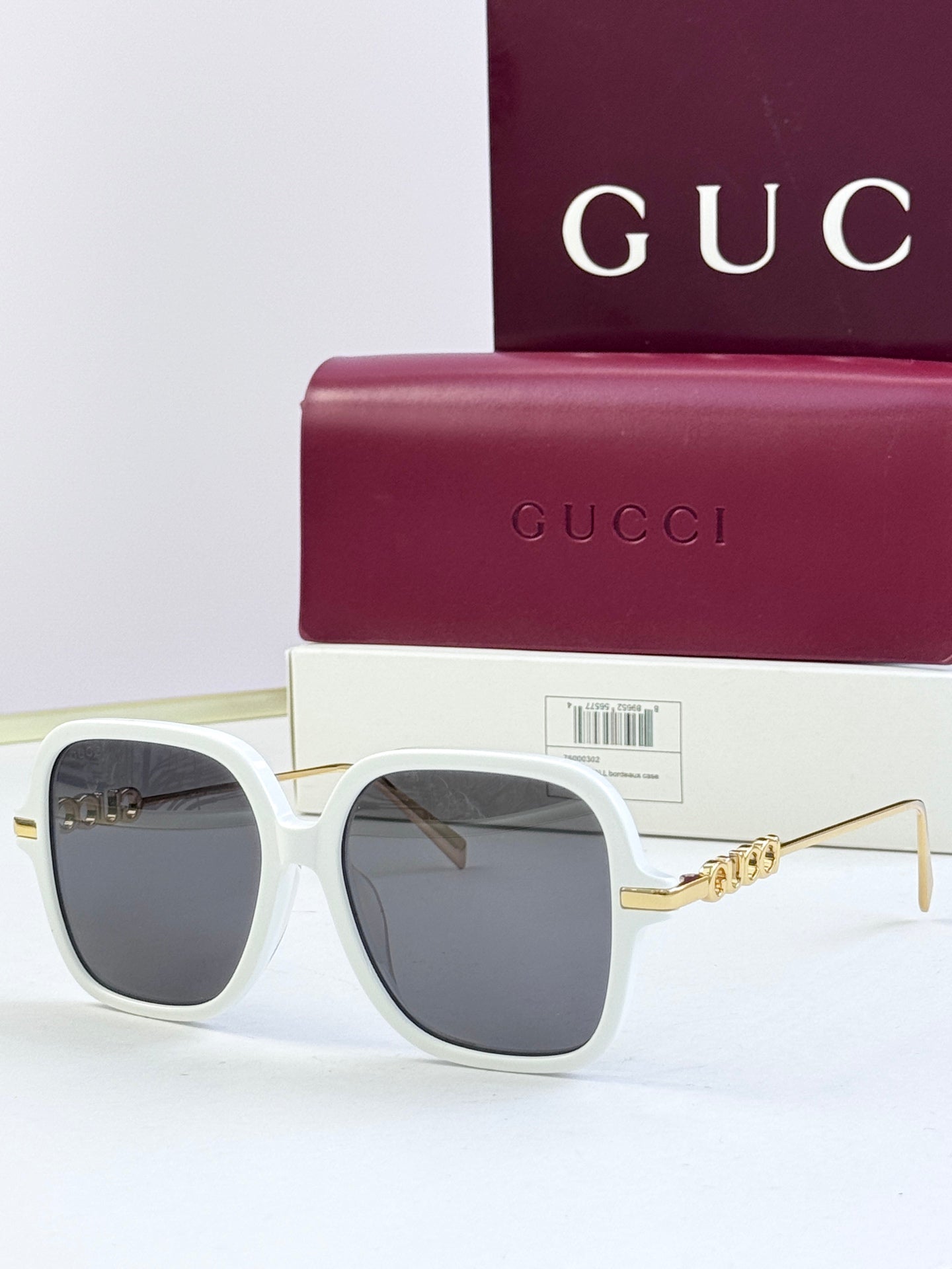 White square sunglasses with dark lenses and gold-tone temple detailing