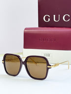 Black square sunglasses with tan-tinted lenses and gold-tone temple detail