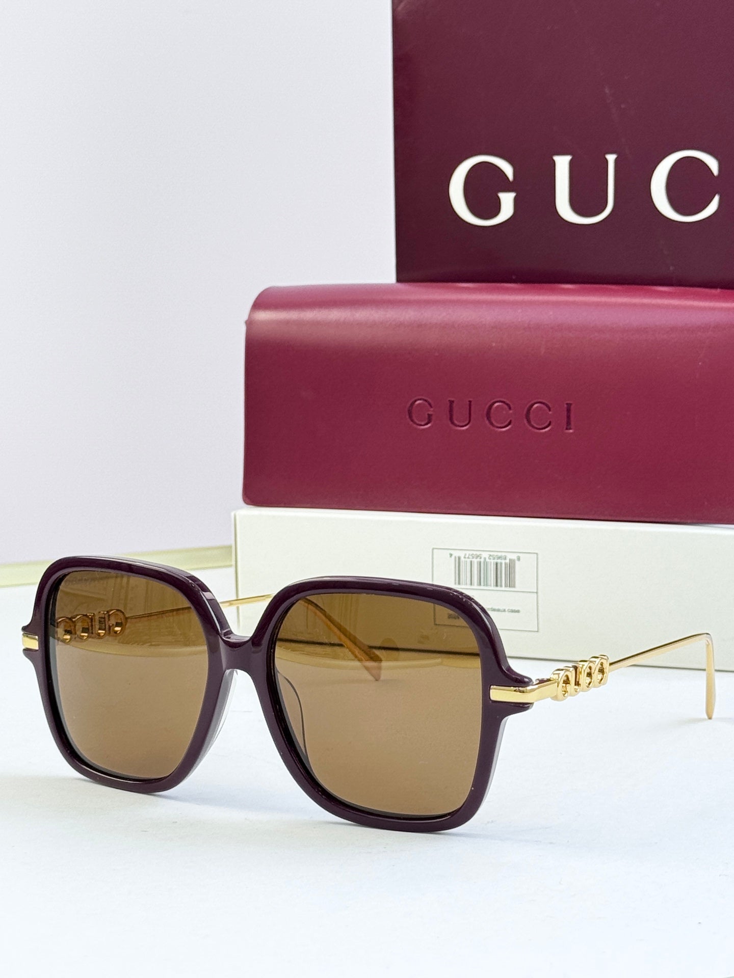 Black square sunglasses with tan-tinted lenses and gold-tone temple detail