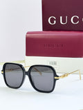 Black square sunglasses with dark lenses and gold-tone temple detailing