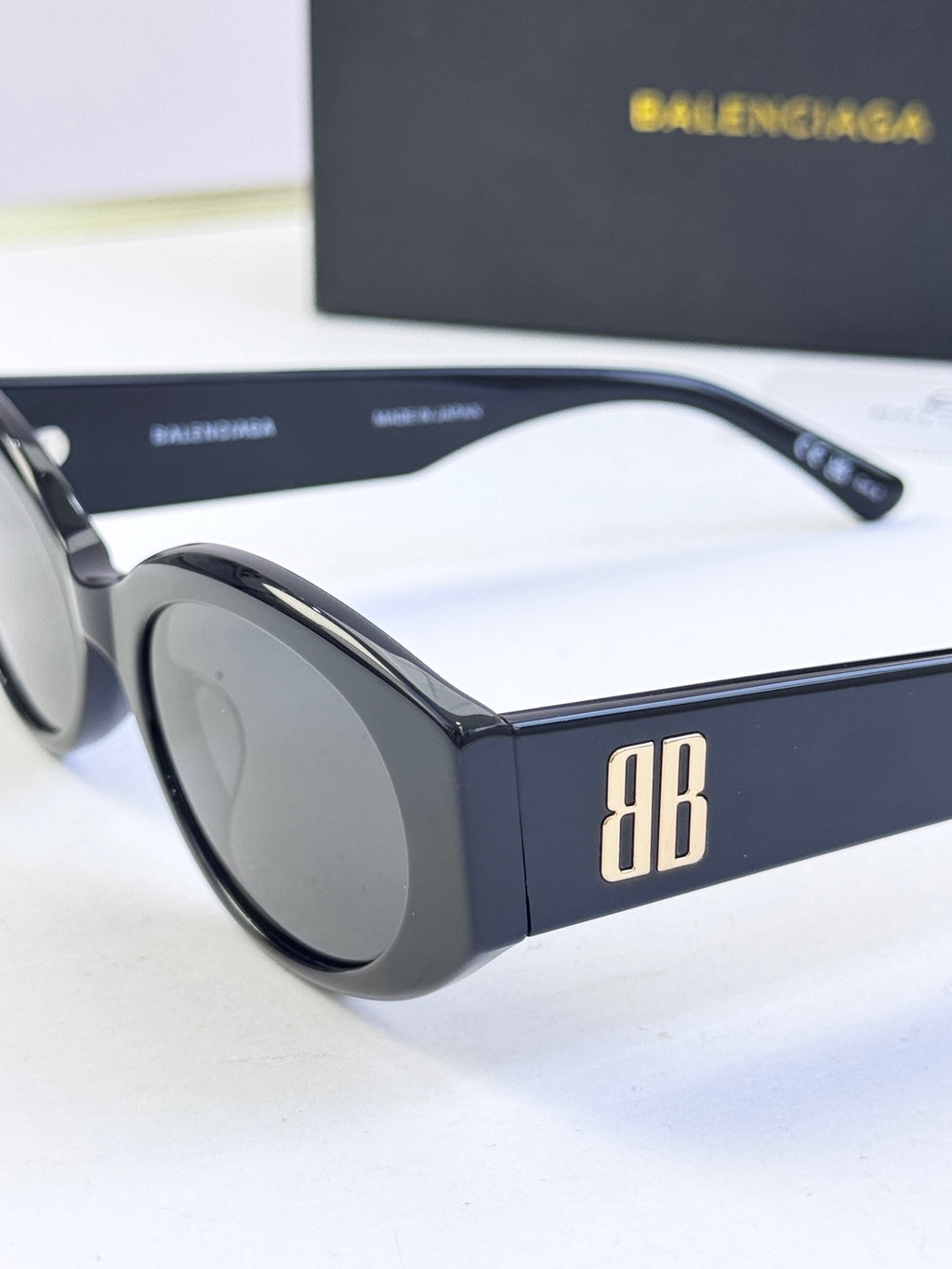 Sunglasses with black frames and dark lenses, temple and front angle