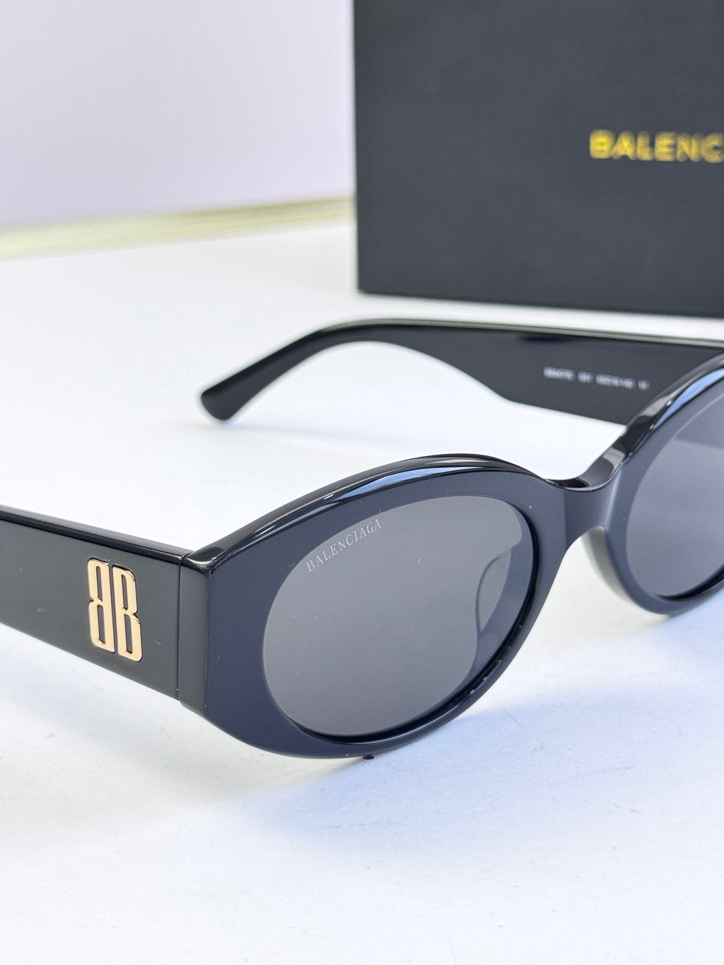 Sunglasses with dark blue-black frames and dark lenses, side view