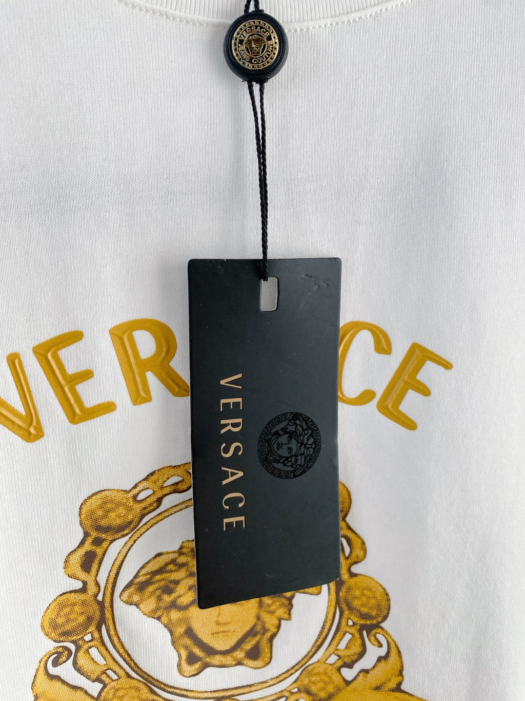 White T-shirt with attached black Versace neck tag