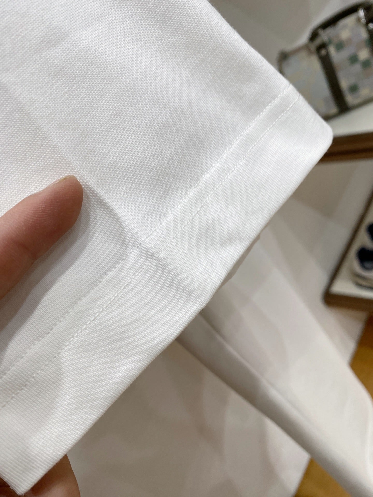 White T-shirt sleeve and stitched hem fabric texture close-up