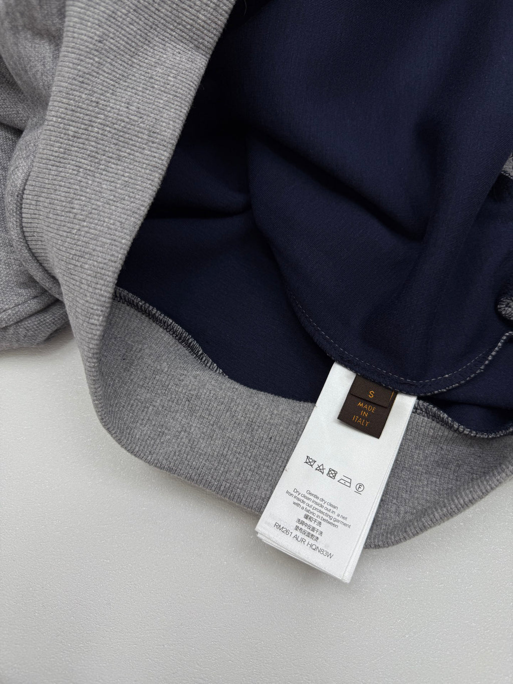 Gray hoodie interior with dark navy hood lining and white product care label