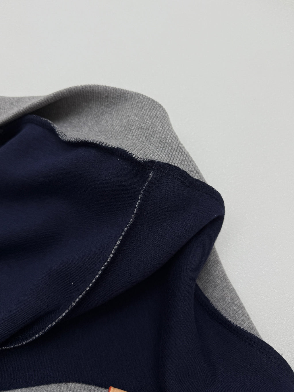 Gray hoodie with dark navy lining along the hood edge and stitched seam