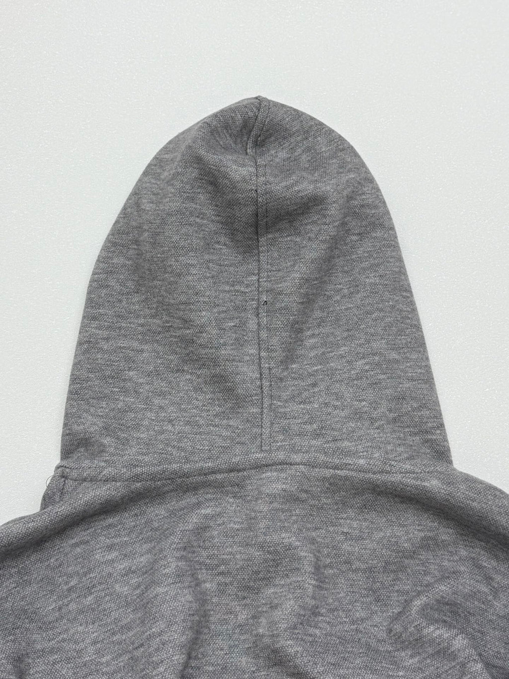 Gray hoodie with pullover hood and center seam detail at the crown