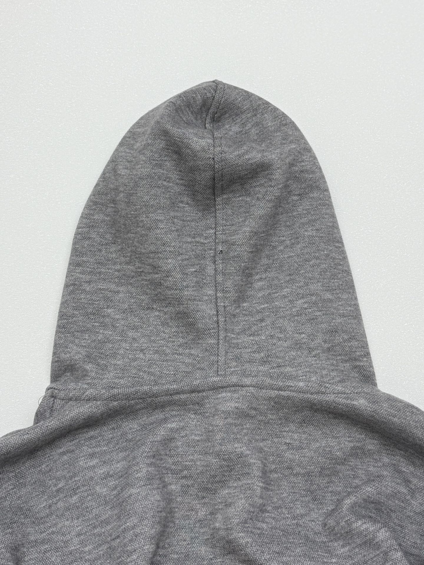 Gray hoodie with pullover hood and center seam detail at the crown