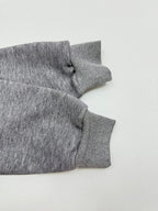 Gray hoodie sleeve with ribbed cuff and gathered seam near the shoulder