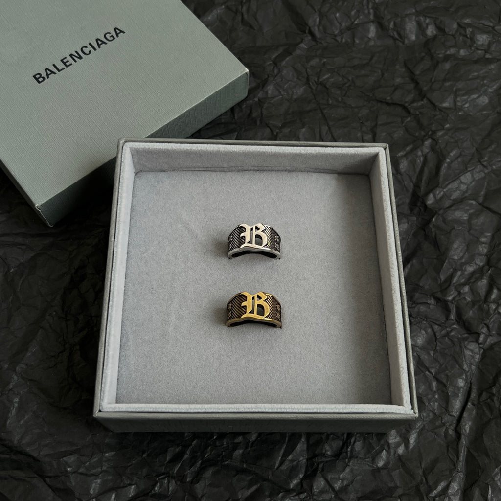 Two logo rings in a gift box, black-and-gold and silver-tone