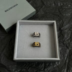 Two logo rings in a gift box, black-and-gold and silver-tone